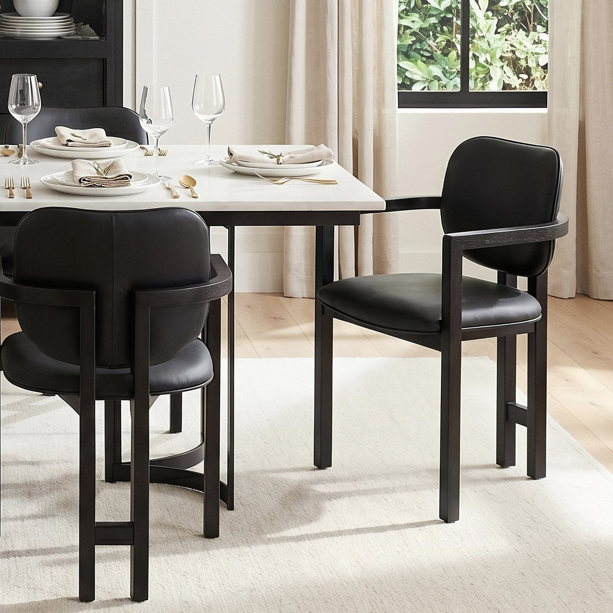 Carlisle Curved Back Black Leather Tripod Frame Dining Armchair from Mercana - Luna Furniture