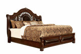 Flandreau Brown queen bed, tufted leatherette headboard and carved footboard, front three-quarter view