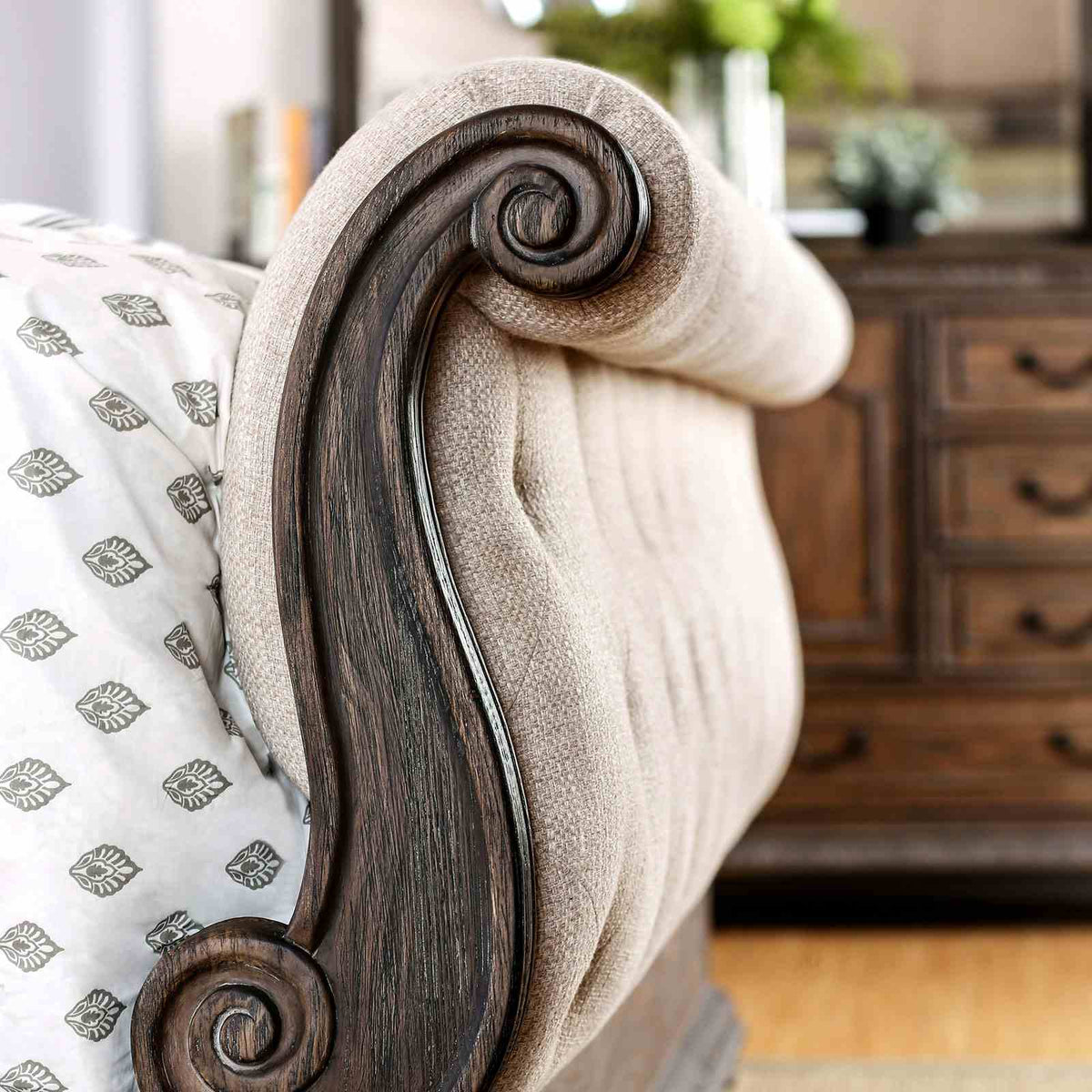 Lysandra Rustic bed footboard detail, button-tufted beige upholstery and carved wood trim