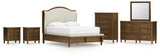 Sturlayne Queen Upholstered Panel Bed with Mirrored Dresser, Chest and 2 Nightstands in Brown from Ashley - Luna Furniture